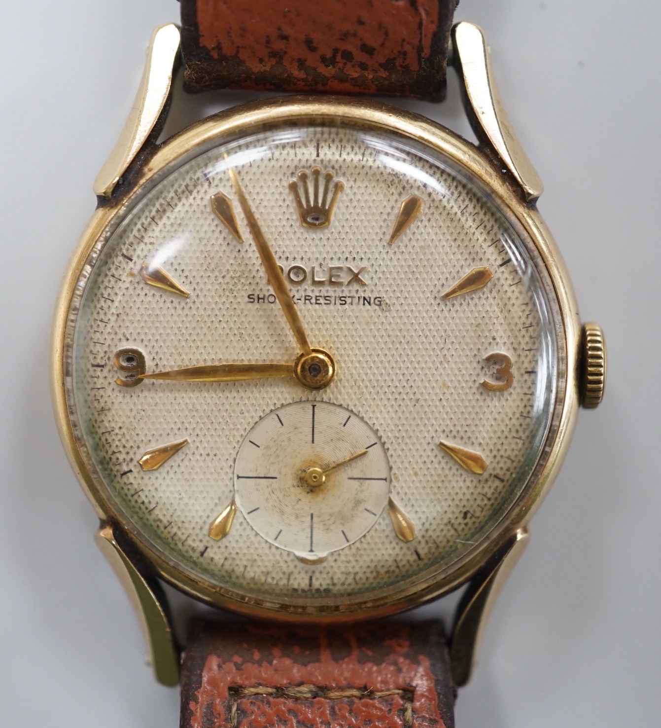 A gentleman's mid 1950's 9ct gold Rolex shock-resisting manual wind wrist watch, with baton and Arabic numerals and subsidiary seconds, on later associated leather strap, case diameter 32mm